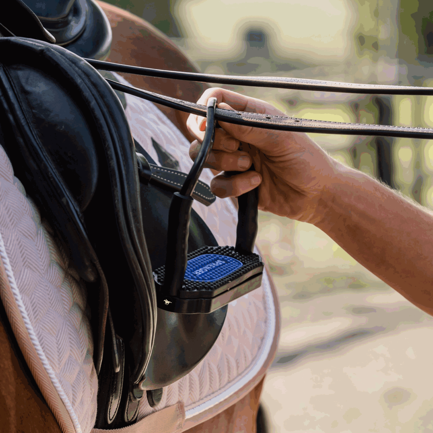 Schwarzer Gelenksteigbügel an braunem Pferd