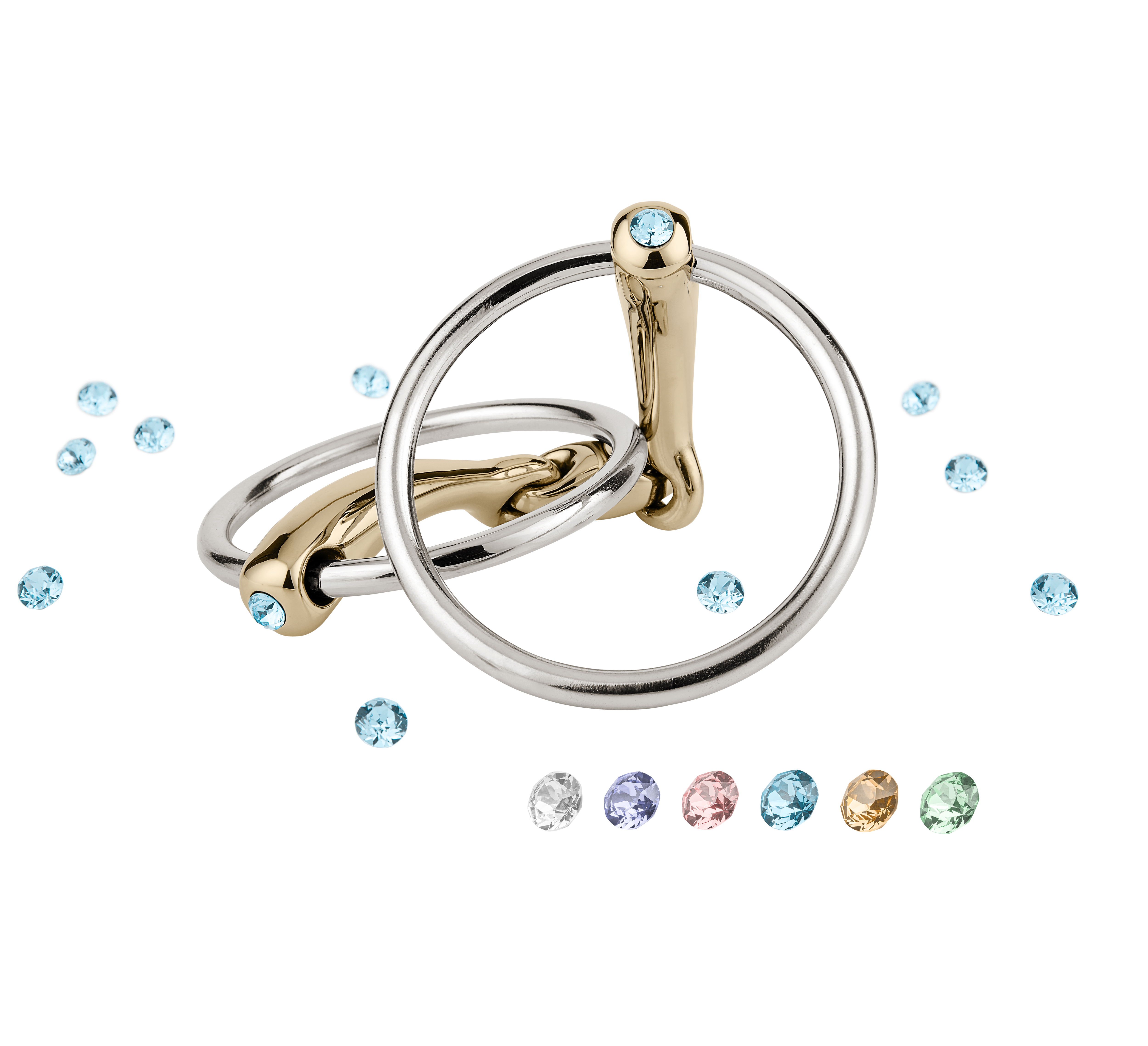 Zwei stylische Ringe aus Gold und Silber, die übereinander liegen. Einer der Ringe zeigt einen blauen Stein. Rund um die Ringe sind verschiedene kleine Schmucksteine in unterschiedlichen Farben angeordnet, darunter Blau, Weiß, Rosa, Lila, Gelb und Grün. Der Hintergrund ist schwarz, wodurch die Ringe und Steine gut zur Geltung kommen.
